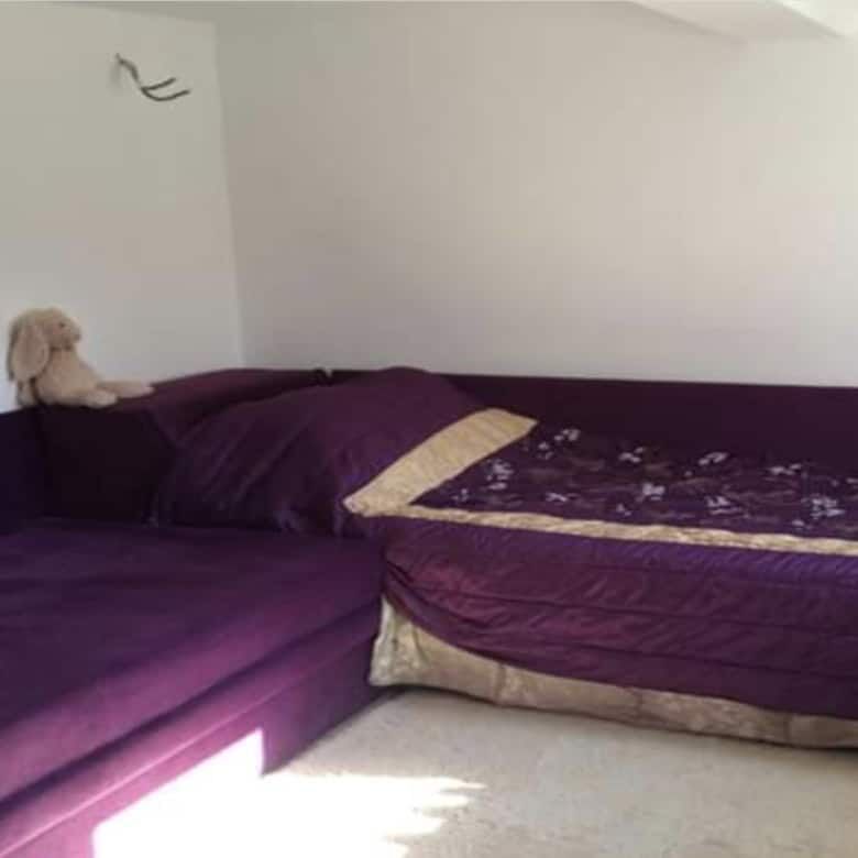 Interior view of a bedroom featuring purple beds and colorful wall art.