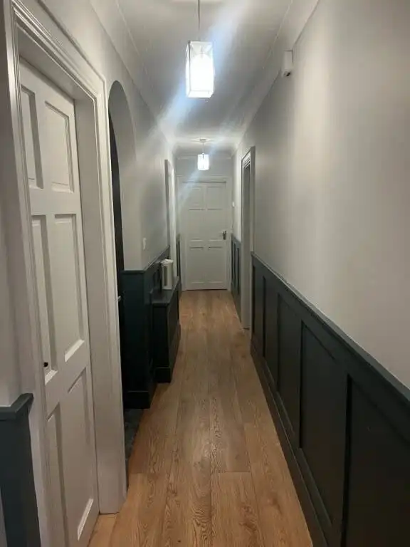 Elegant hallway with white walls and dark wainscoting in a spacious estate in Tooreen Kilcolgan Galw.