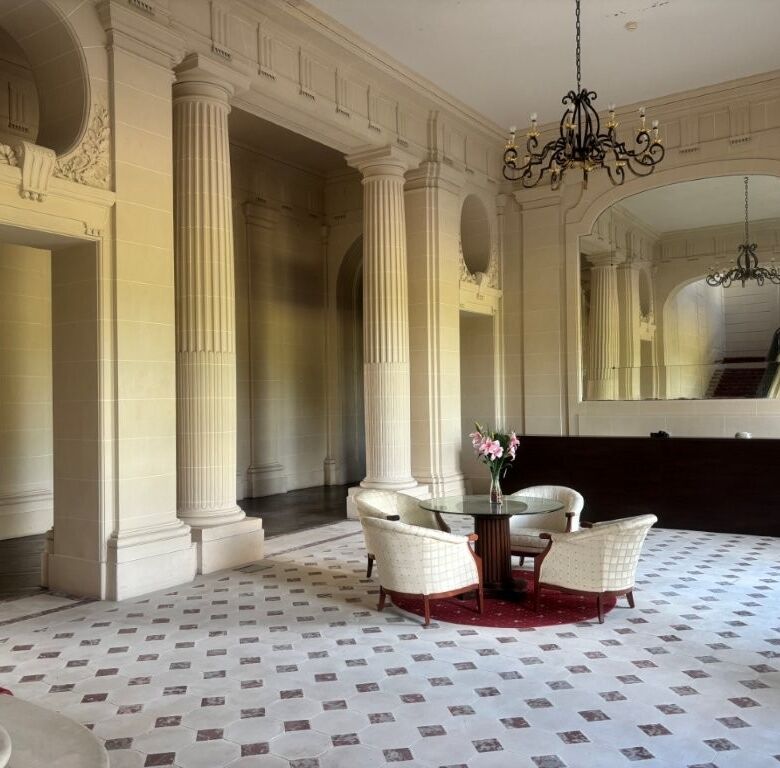 Luxurious Château du Francport apartment interior with classical columns and elegant furnishings.