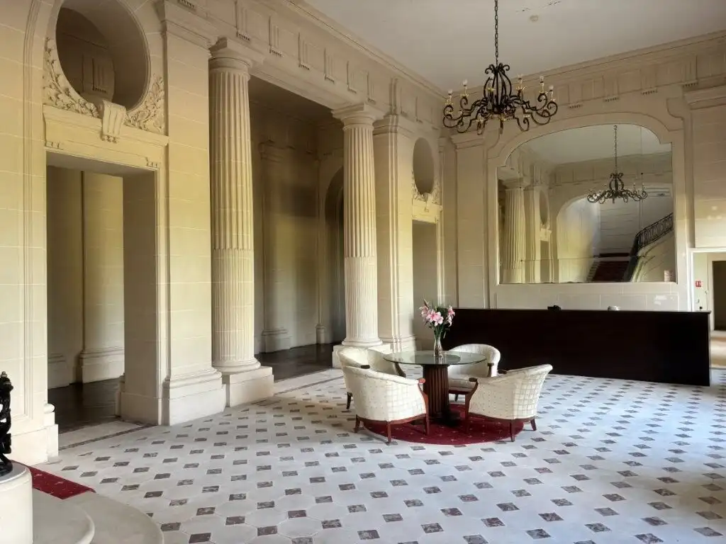 Luxurious Château du Francport apartment interior with classical columns and elegant furnishings.