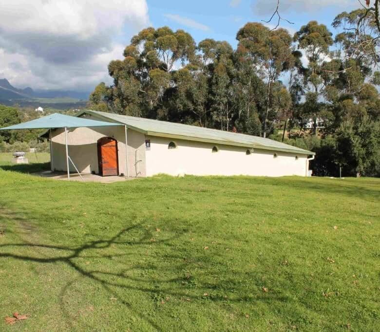 Estate house with lush green lawn and scenic mountain views in Wellington, Western Cape.