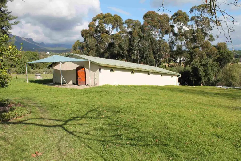 Estate house with lush green lawn and scenic mountain views in Wellington, Western Cape.