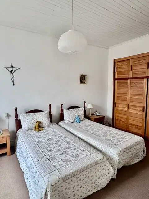 Comfortable twin beds with floral bedding in a bright, simple bedroom setting.