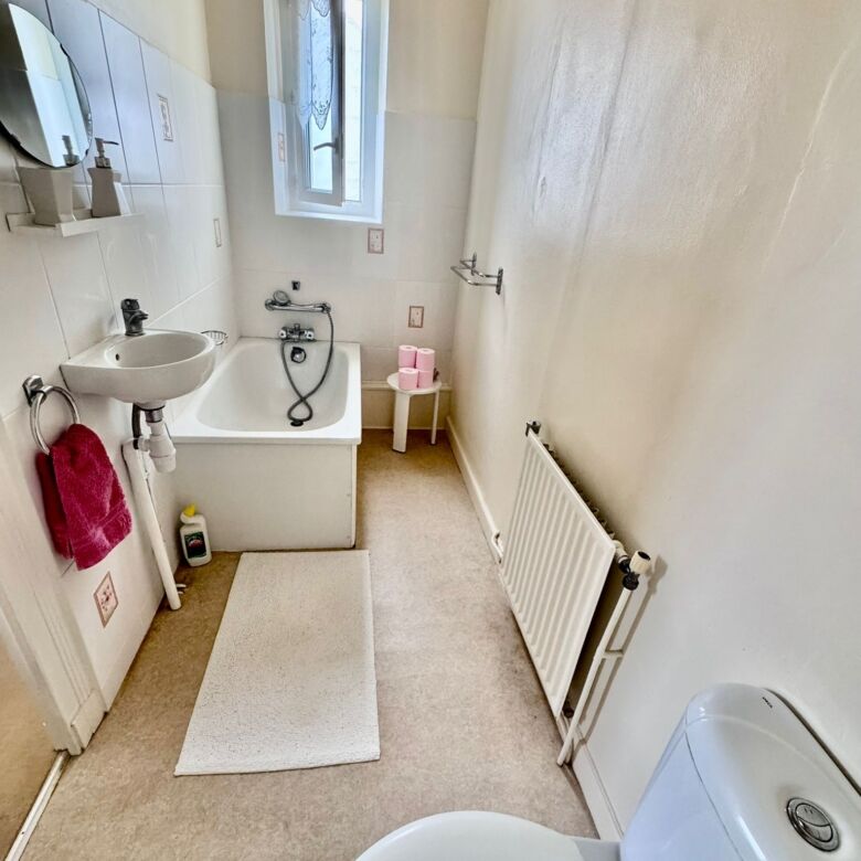 Bright bathroom with bathtub, toilet, and sink in a charming French townhouse.