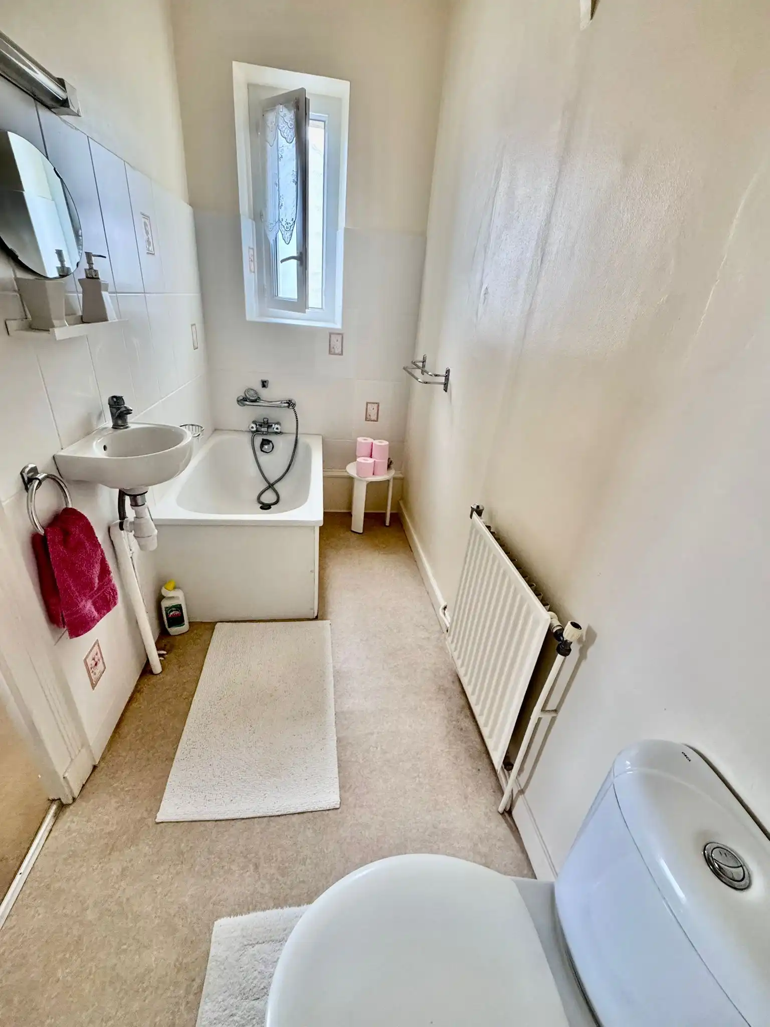 Bright bathroom with bathtub, toilet, and sink in a charming French townhouse.