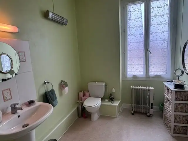 Spacious bathroom with sink, toilet, and storage in a bright, airy room.