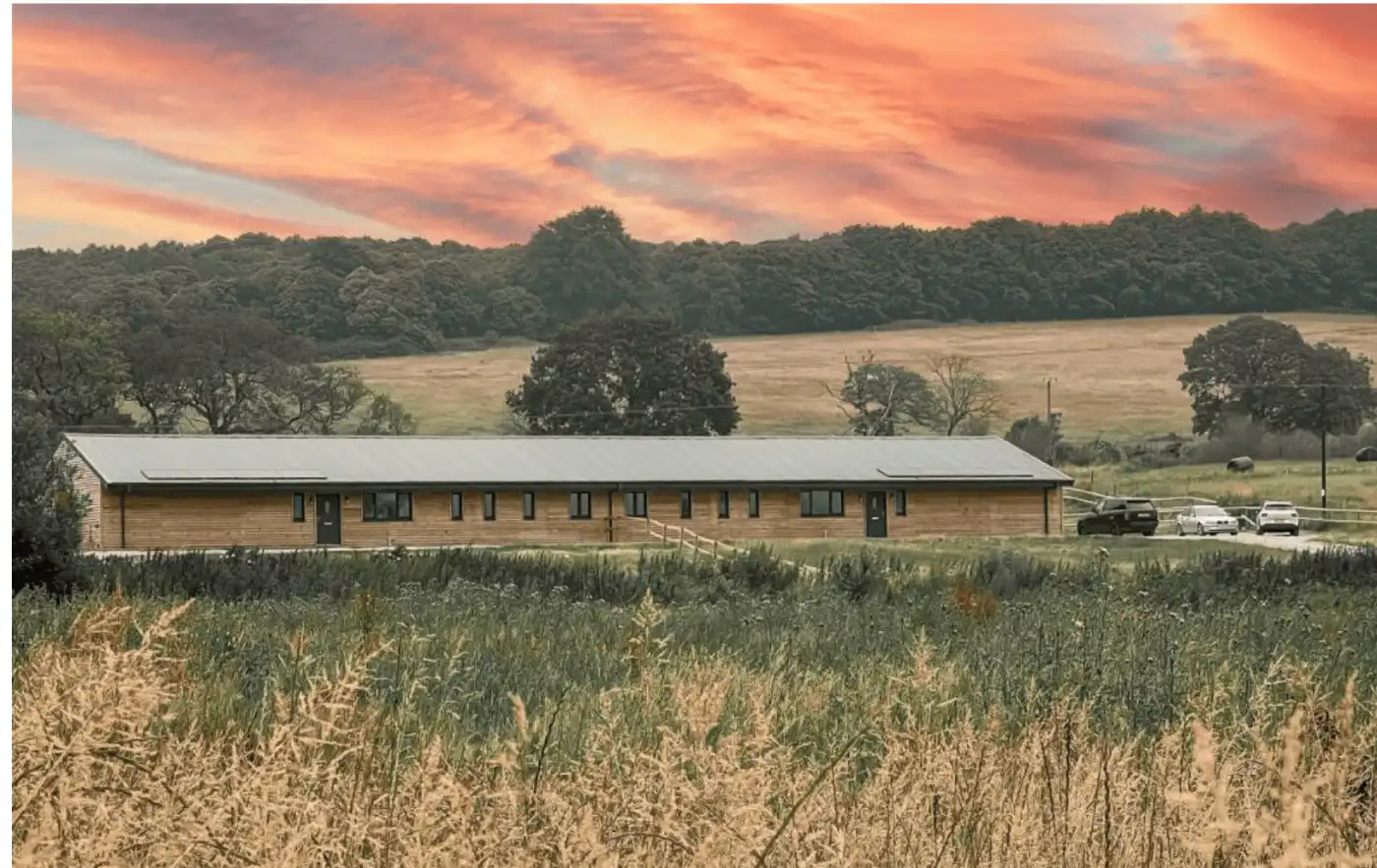 Barn Conversion in Surrey with picturesque rural landscape and sunset sky.