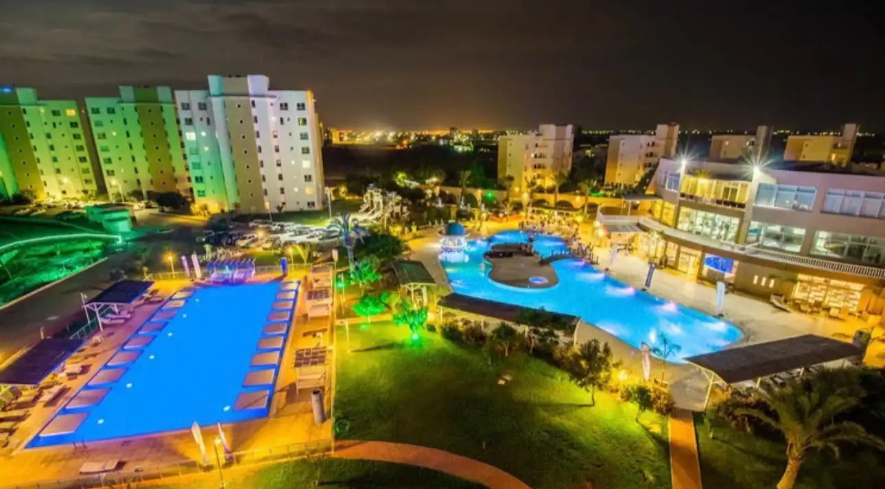 Apartment in Caesar Resort with pool and resort amenities at night.