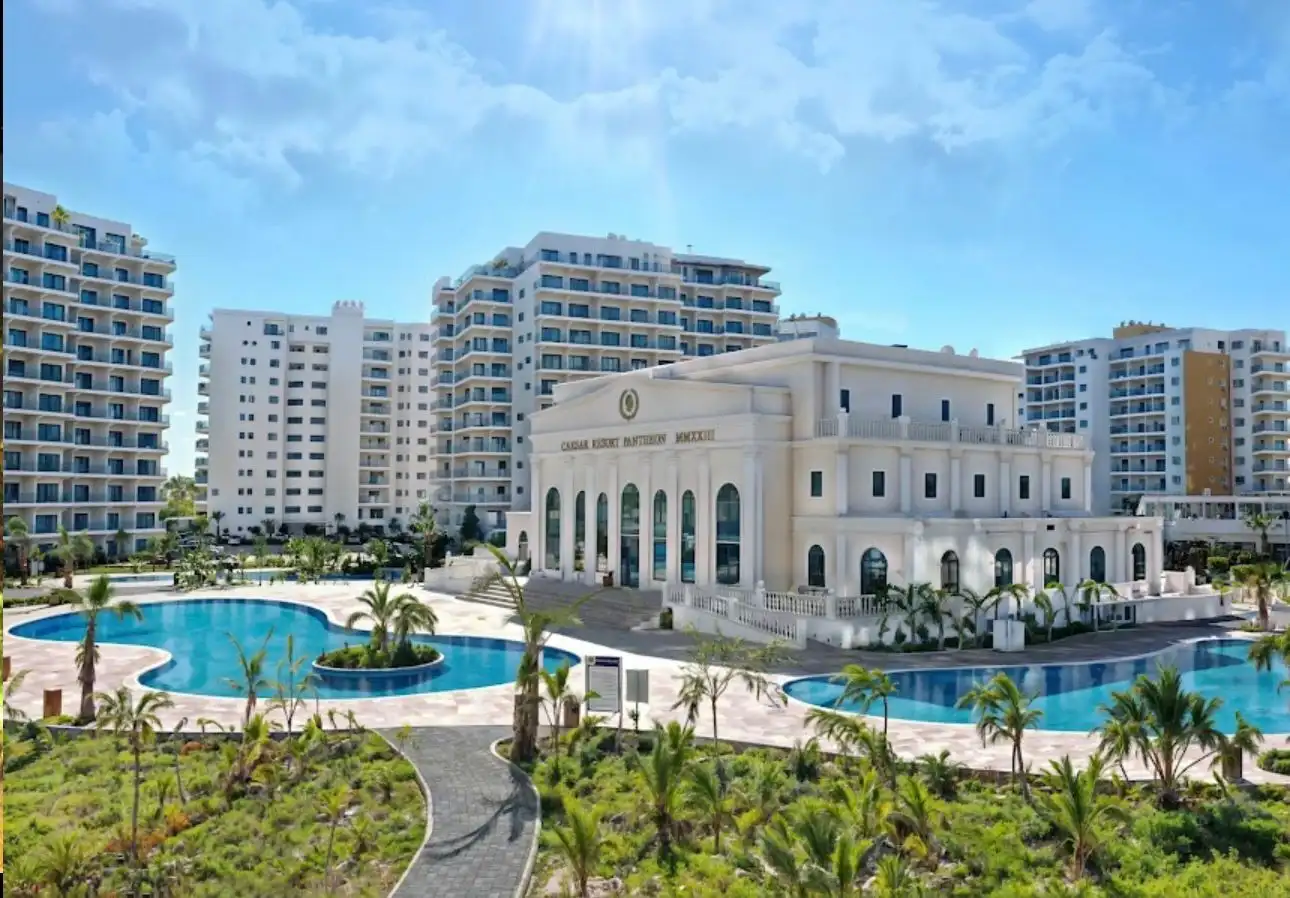 Apartment complex with pools and lush landscaping in Caesar Resort, Iskele.