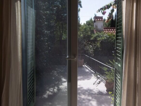 Sliding glass door to balcony with lush greenery view in Split.