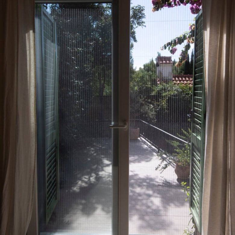 Sliding glass door to balcony with lush greenery view in Split.