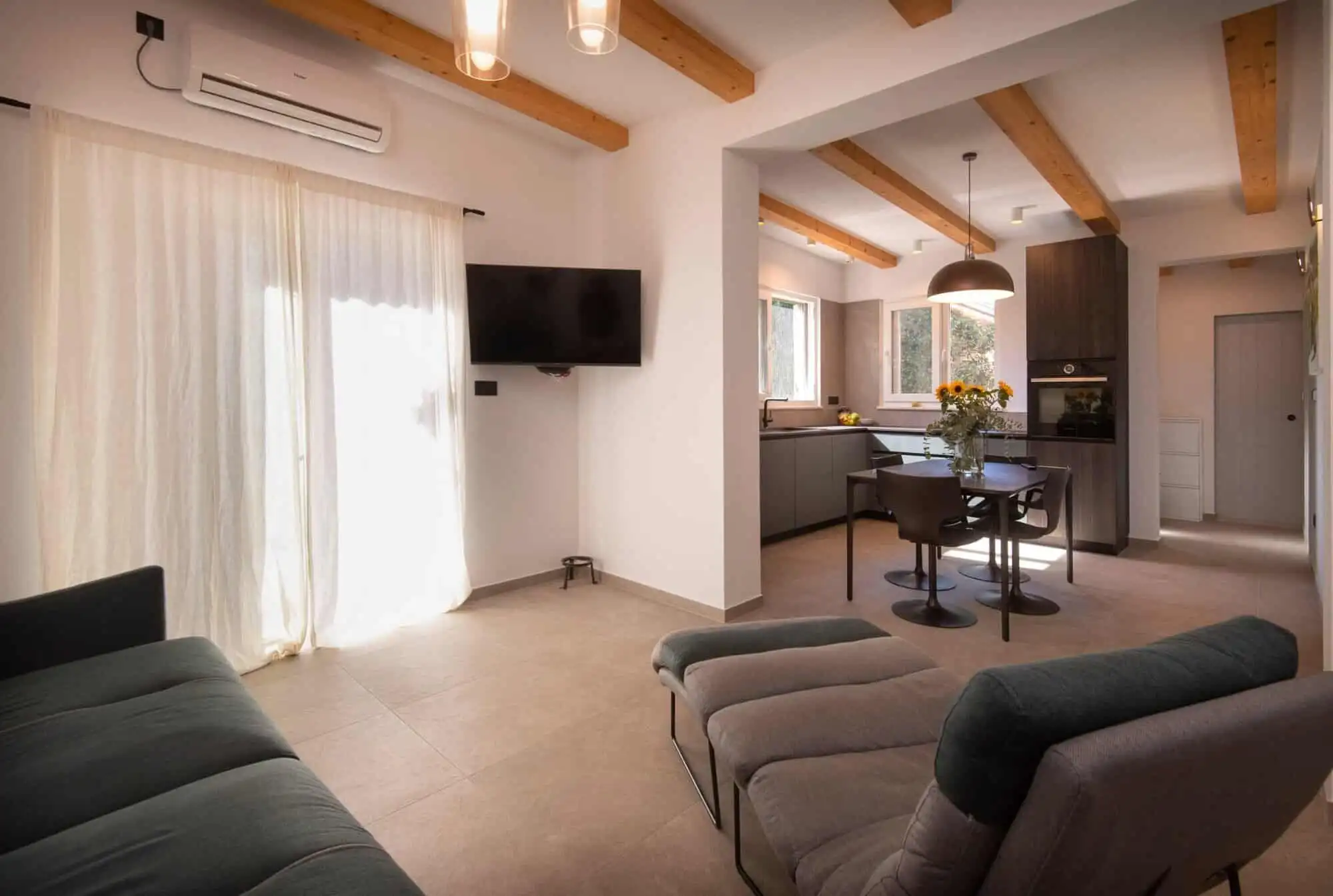 storey house interior in Split’s exclusive area. Cozy living room with large windows, neutral decor, and contemporary furnishings.