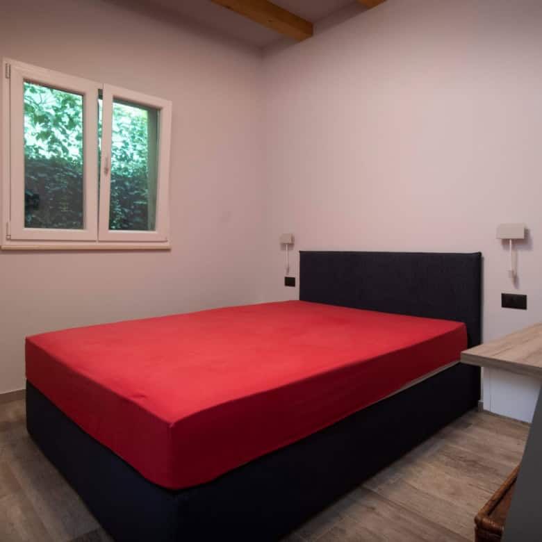 Modern bedroom with large window and minimalist decor.