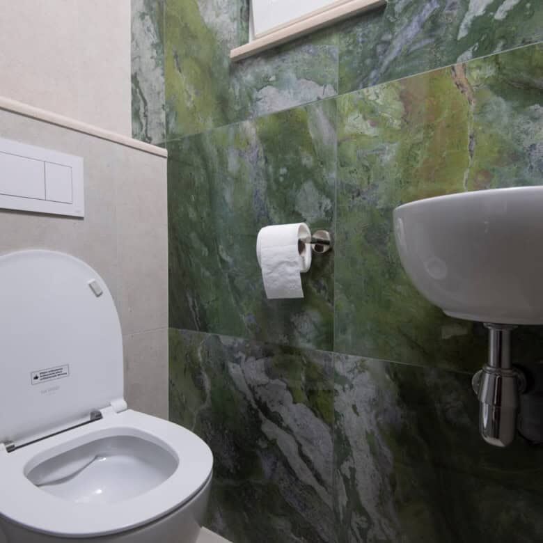 Modern bathroom in a luxurious Split home with green marble walls and sleek fixtures.