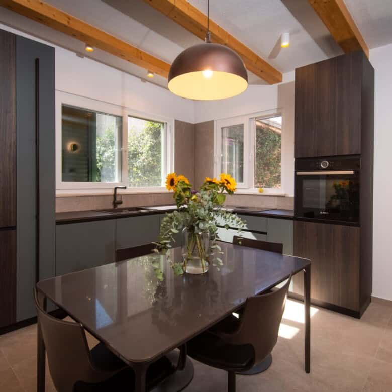 Modern kitchen with dark cabinetry and large windows in Split.