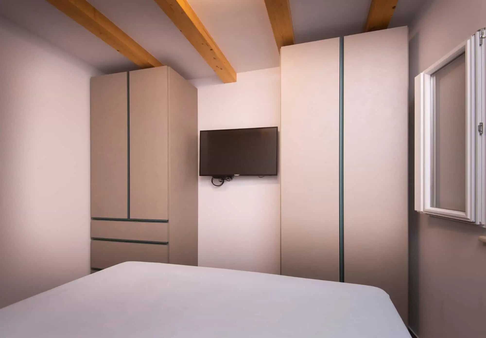 Modern bedroom with built-in wardrobes and a wall-mounted TV in a high-end Split home. Modern bedroom with built-in wardrobes and a wall-mounted TV in a high-end Split home.