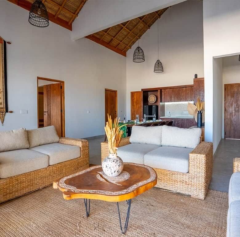 Luxury beachfront villa living room with natural rattan furniture and high vaulted ceilings in Sumba.