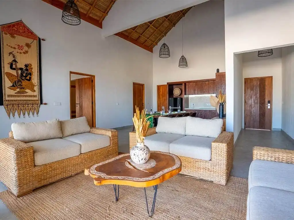 Luxury beachfront villa living room with natural rattan furniture and high vaulted ceilings in Sumba.
