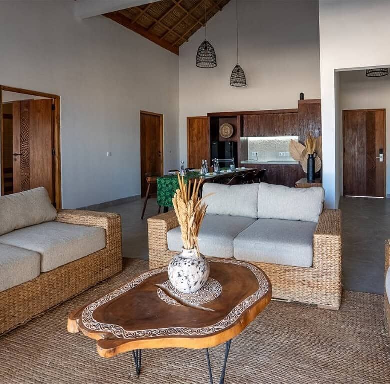 Luxury beachfront villa living room with natural wood accents and modern furnishings in Sumba.
