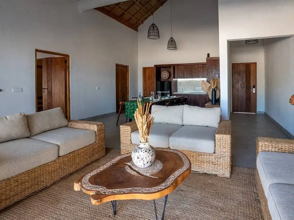 Luxury beachfront villa living room with natural wood accents and modern furnishings in Sumba.