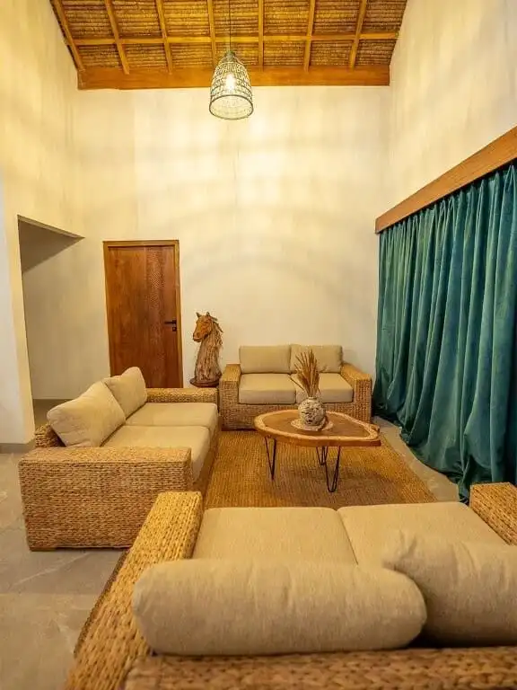 Elegant beachfront villa living room with rattan furniture and high ceiling in Sumba.