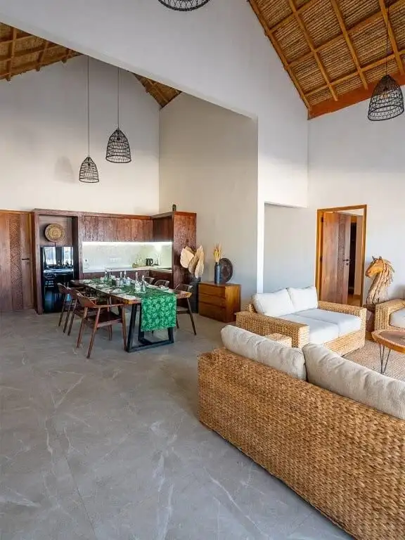 Luxury beachfront villa interior with modern furnishings and high vaulted ceiling.