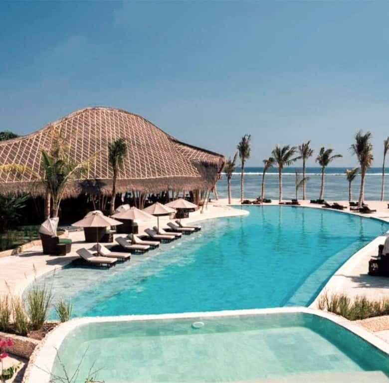 Eco-luxury beachfront resort villas with pool and palm trees in Sumba, Indonesia.