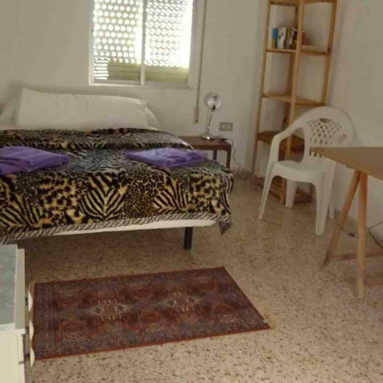 Bright bedroom featuring a large window and simple decor in Valencia property.