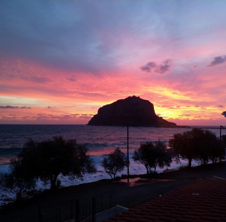 Beautiful sunset over Monemvasia with sea view and rocky island backdrop.