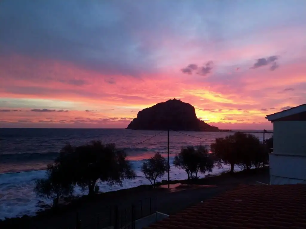 Beautiful sunset over Monemvasia with sea view and rocky island backdrop.