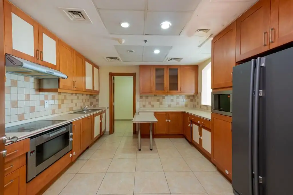 Bright kitchen featuring wooden cabinets and stainless steel appliances. Perfect for cooking and ent.