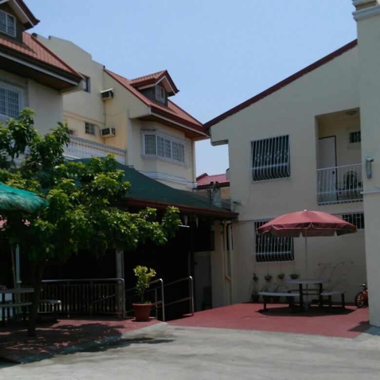 Modern family resort hotel in Cavite with outdoor seating area and lush greenery.
