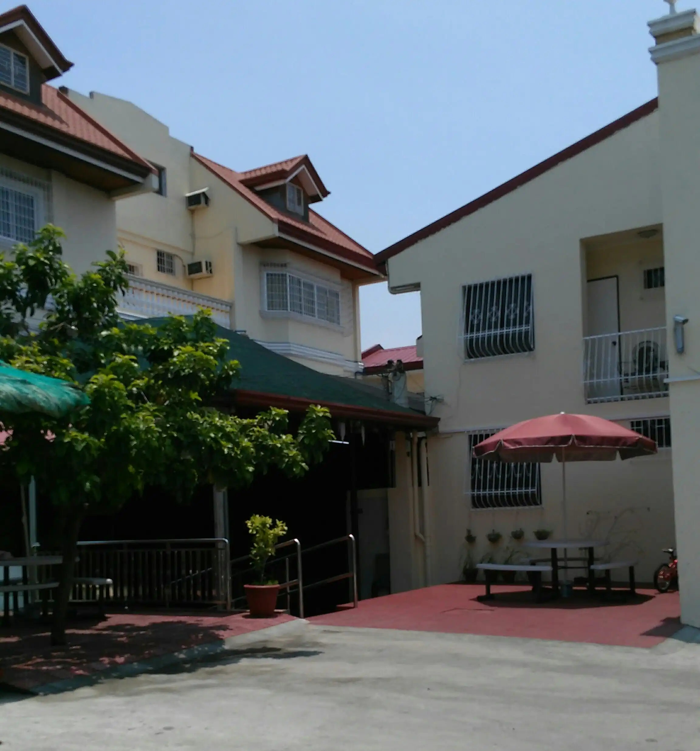 Modern family resort hotel in Cavite with outdoor seating area and lush greenery.