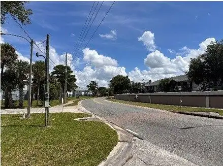 Plot of land for sale in Orlando, Florida with clear skies and residential surroundings.