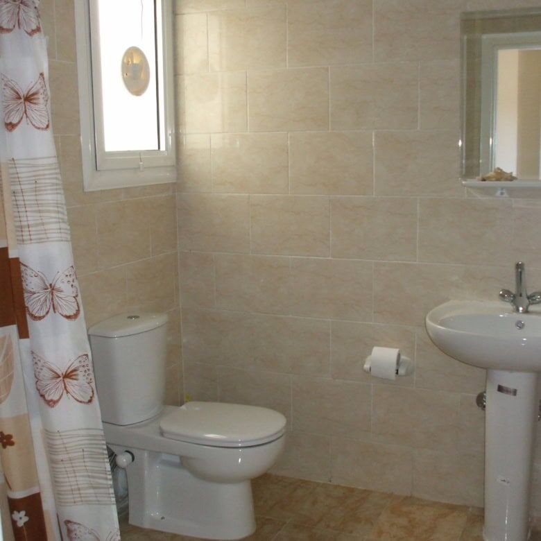 Bathroom with toilet, sink, and mirror in a contemporary apartment.