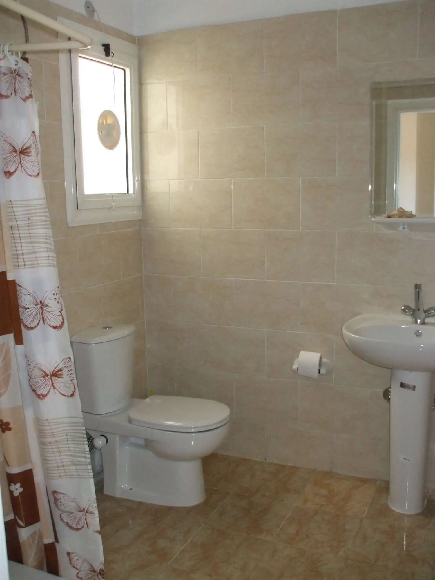 Bathroom with toilet, sink, and mirror in a contemporary apartment.