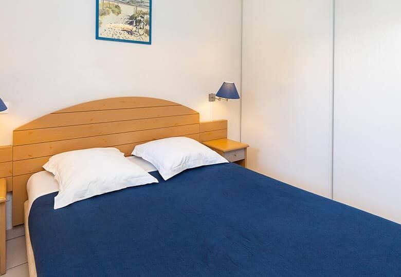 Spacious bedroom with a comfortable bed and modern decor in Dunes Ondre.