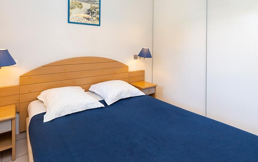 Spacious bedroom with a comfortable bed and modern decor in Dunes Ondre.