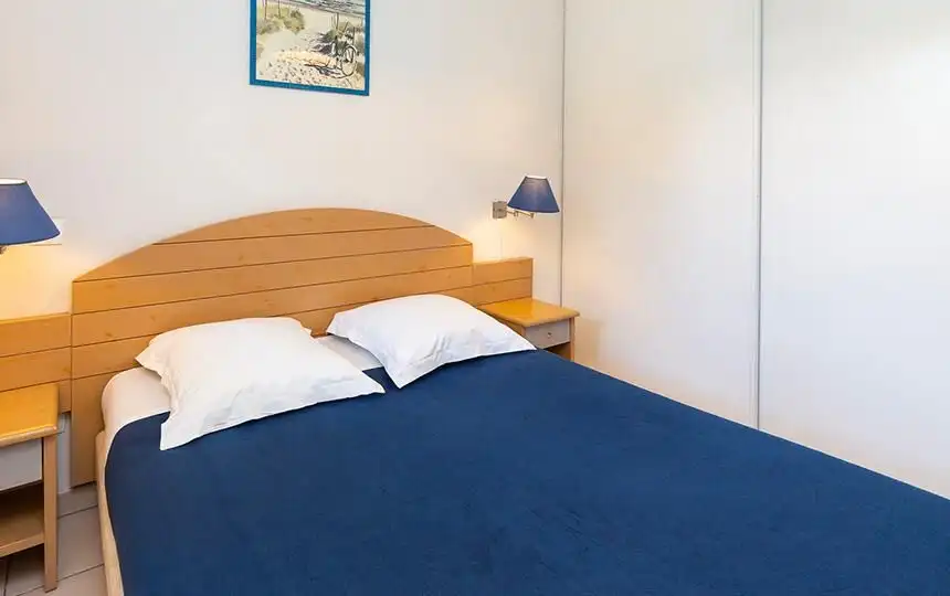 Spacious bedroom with a comfortable bed and modern decor in Dunes Ondre.