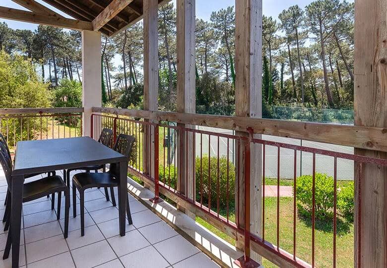 Balcony overlooking lush greenery and trees, perfect for relaxing or outdoor dining.