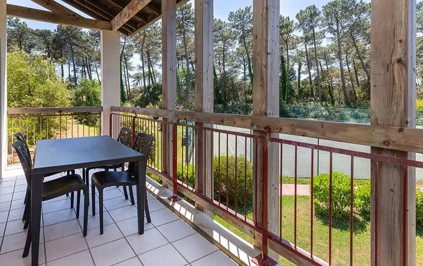 Balcony overlooking lush greenery and trees, perfect for relaxing or outdoor dining.