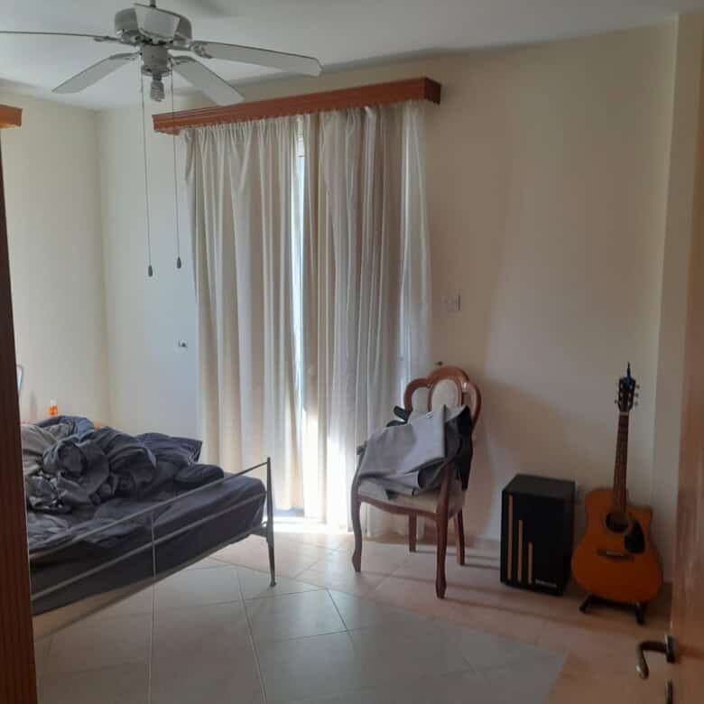Spacious living room with large window and natural light in a 4-bedroom villa in Aradippou, Larnaca.