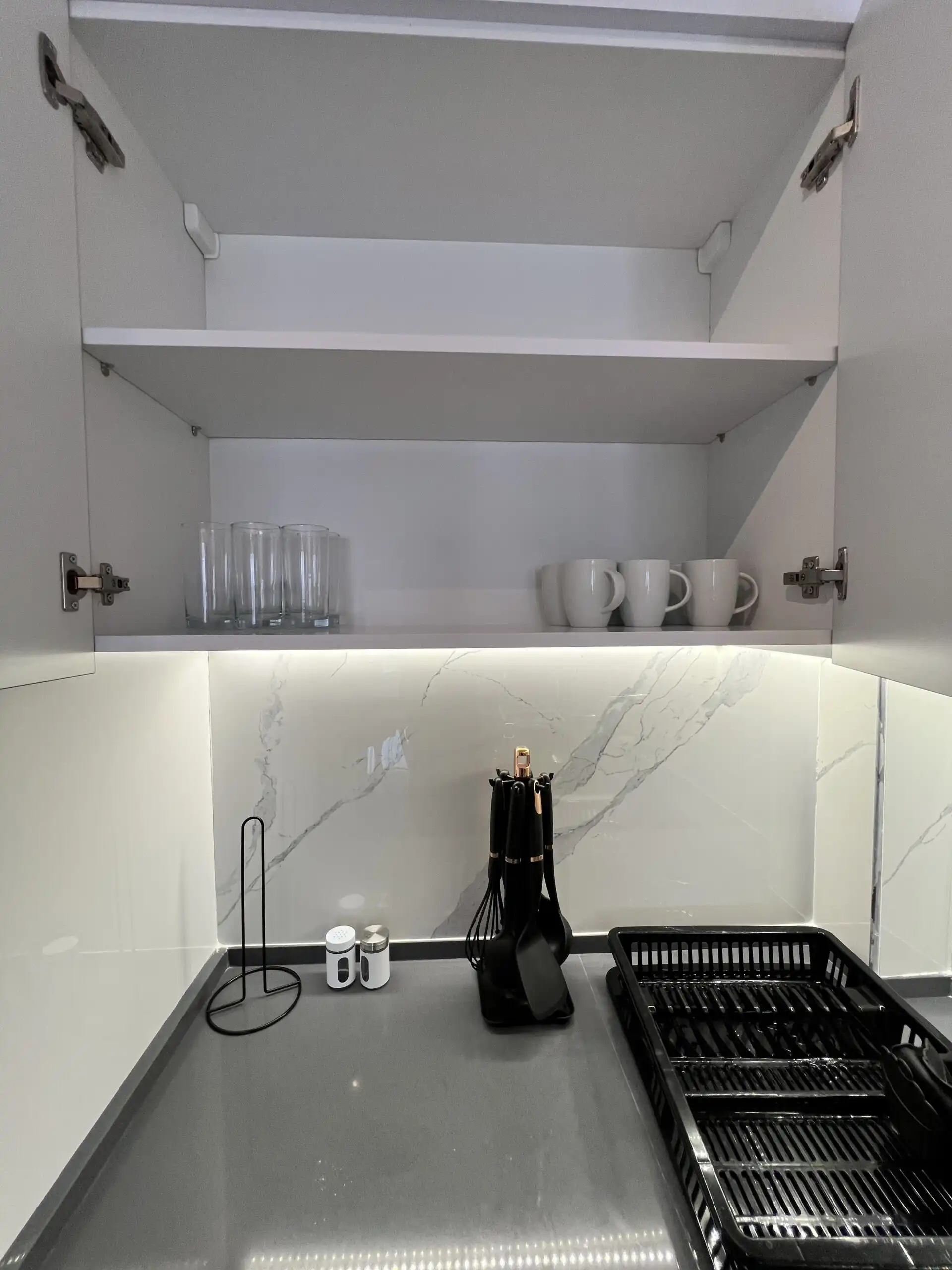 Modern kitchen with white cabinets and marble backsplash in Caesar Resort, Iskele.