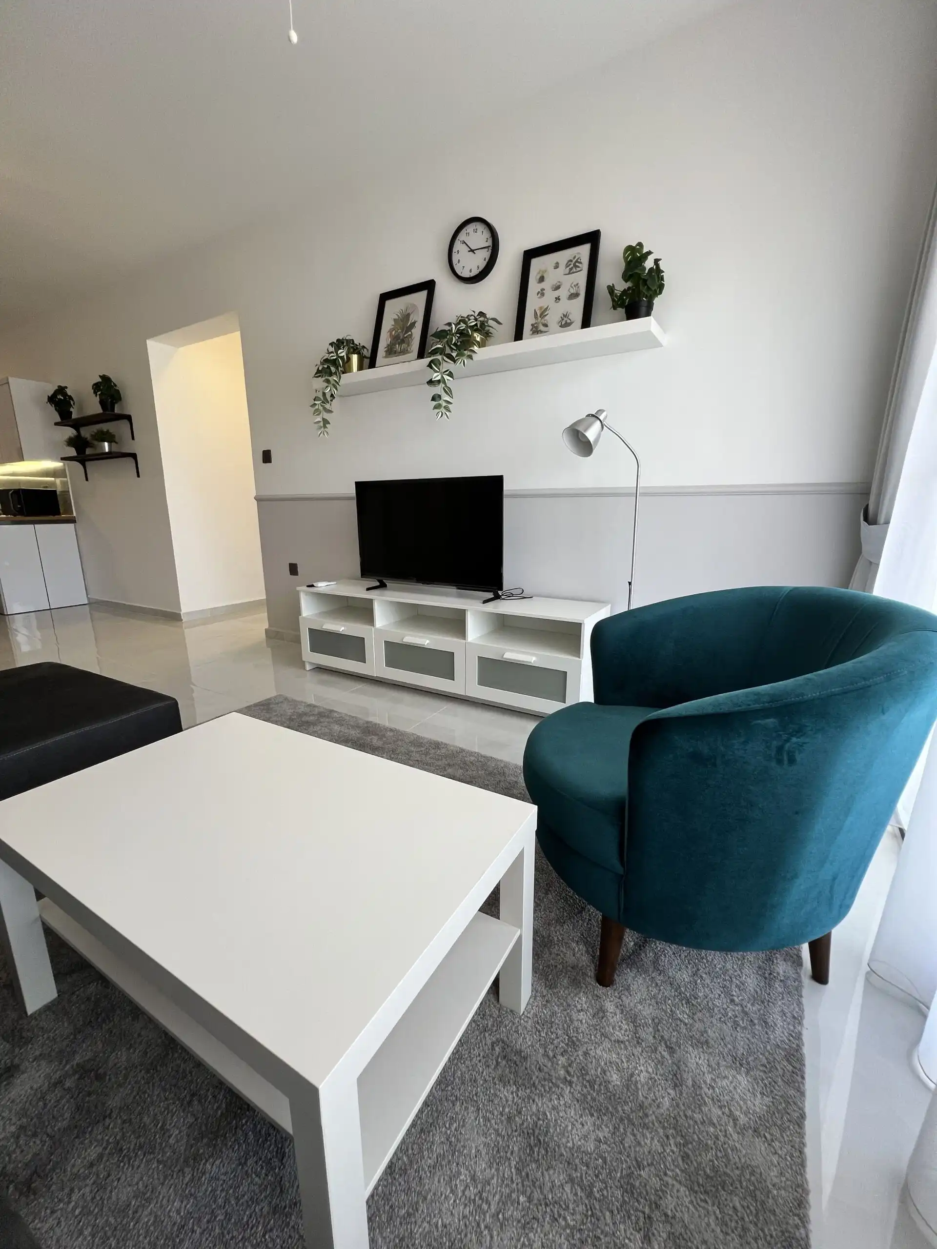Cozy living room with TV, wall decor, and stylish furniture in Caesar Resort.