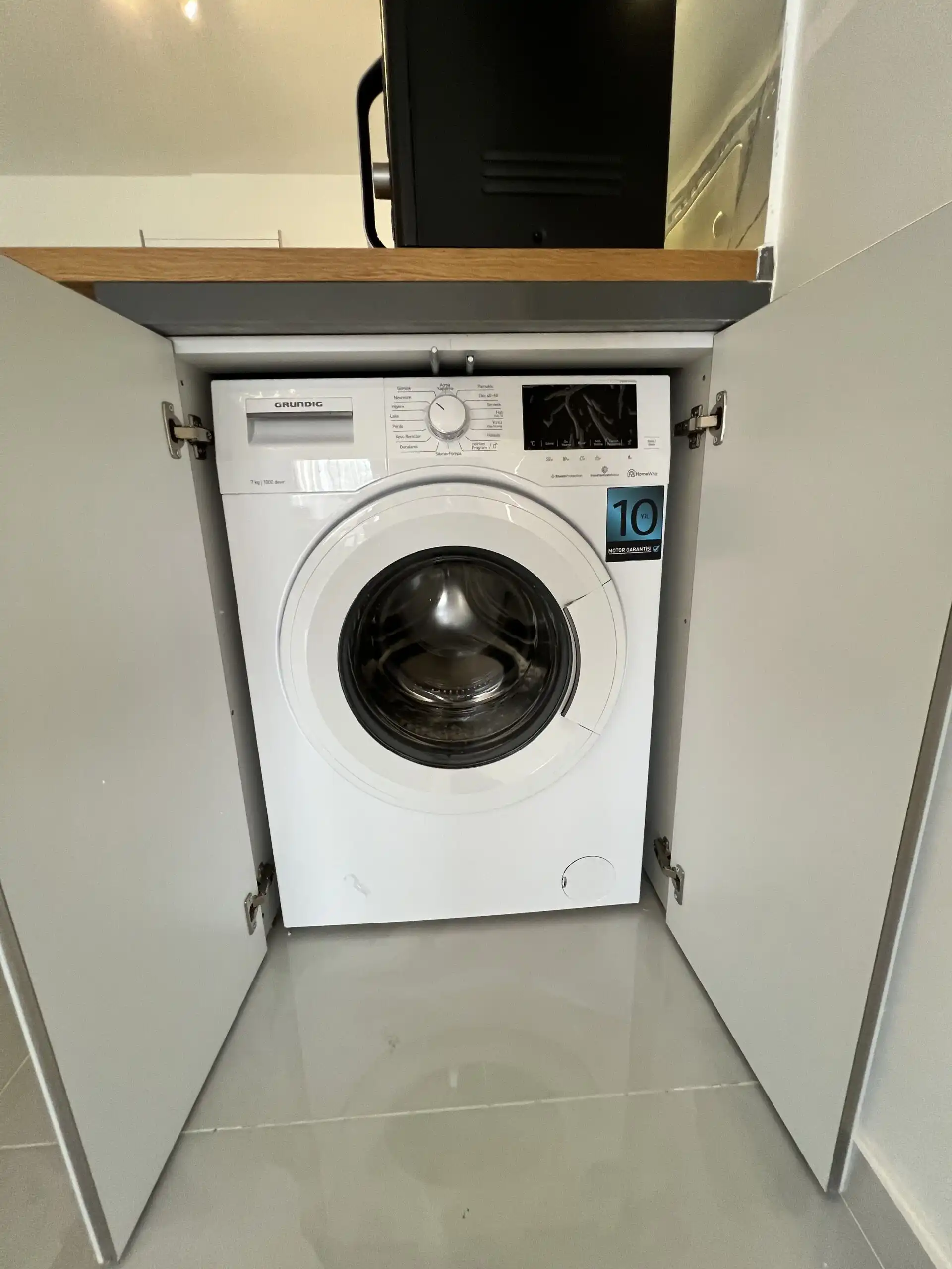 Compact washing machine in Caesar Resort apartment.