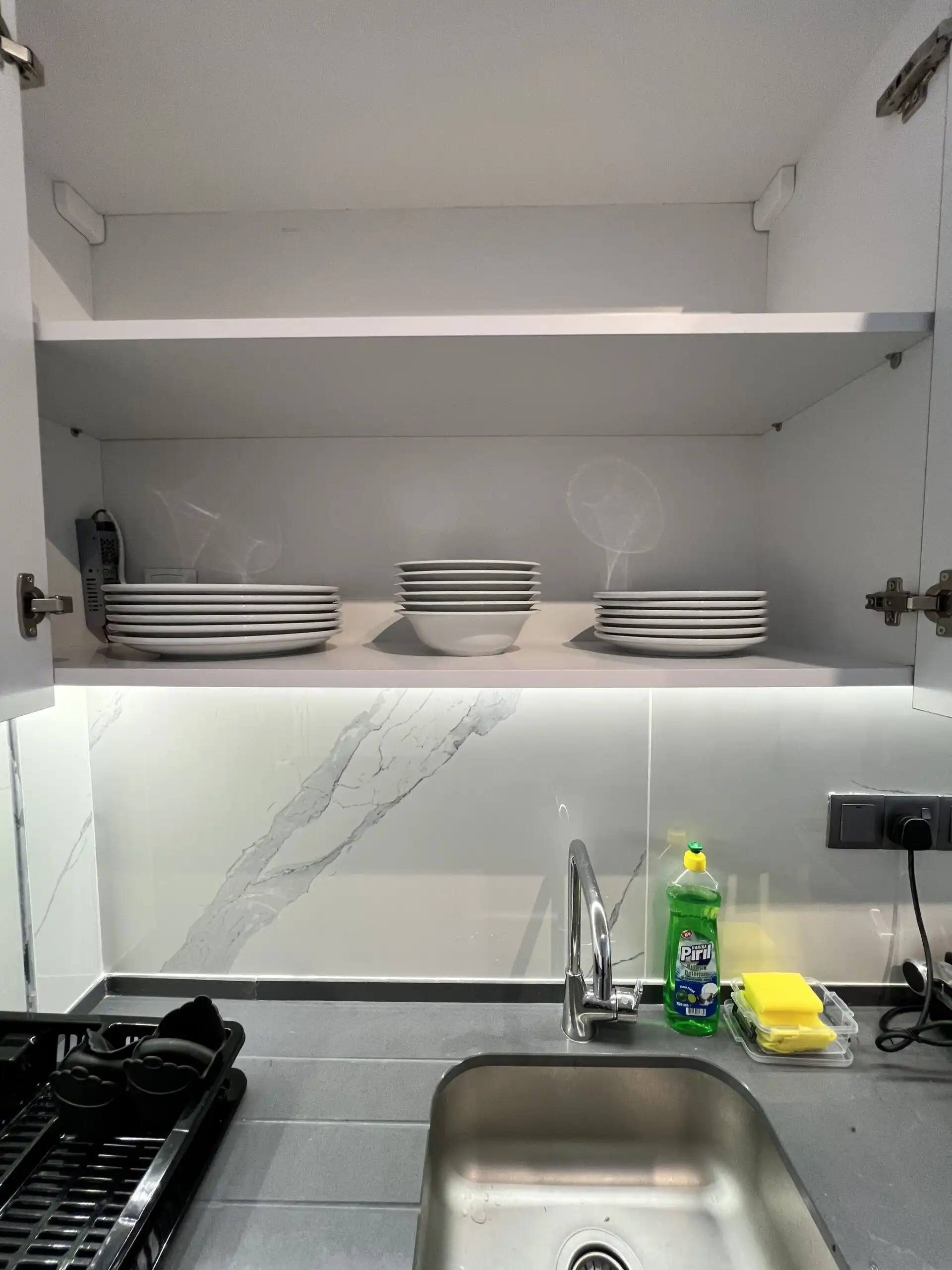 Modern kitchen with white cabinets, marble backsplash, and kitchen essentials in Caesar Resort apart.