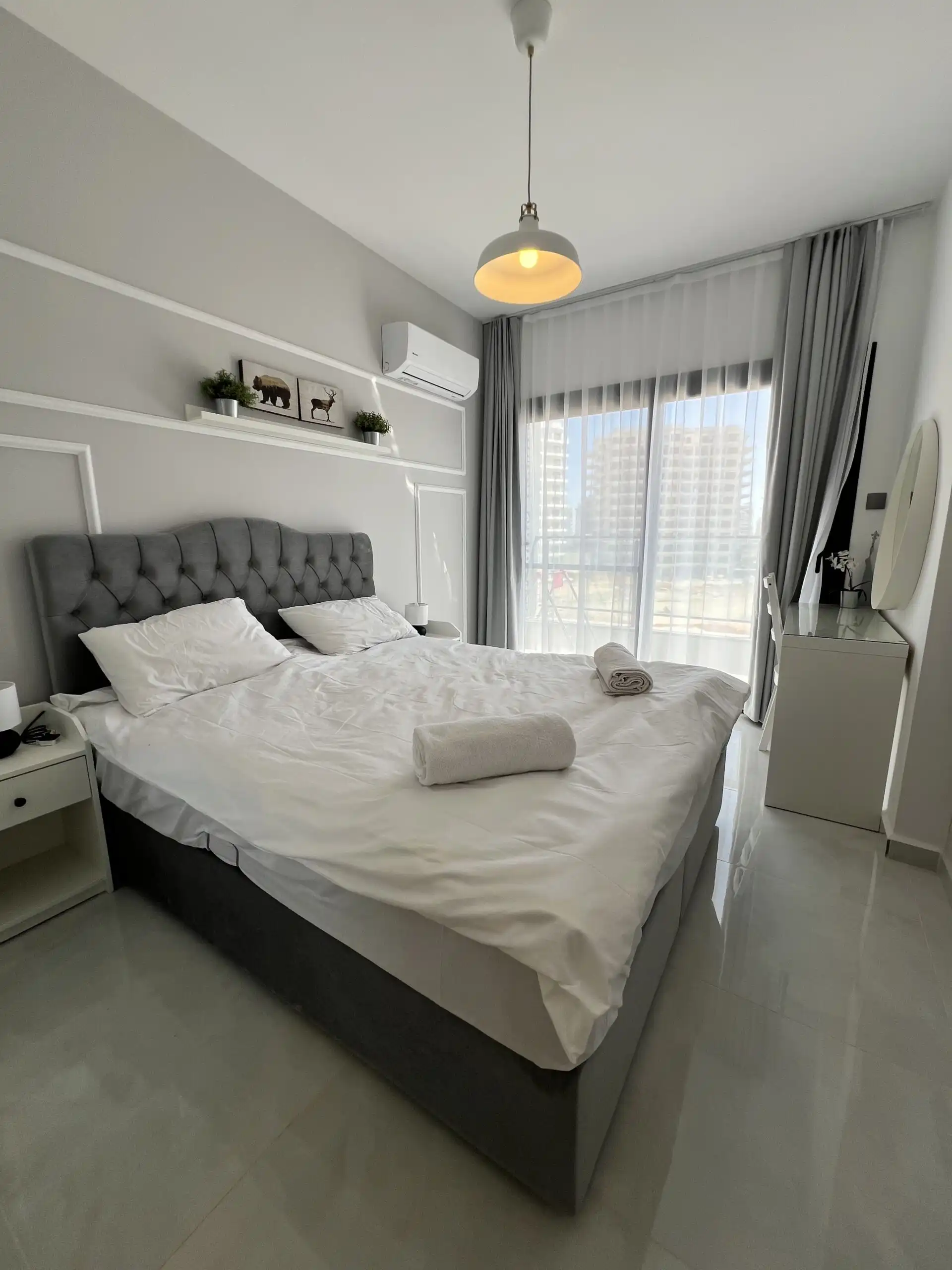 Bright bedroom in Caesar Resort with modern decor and large window view.