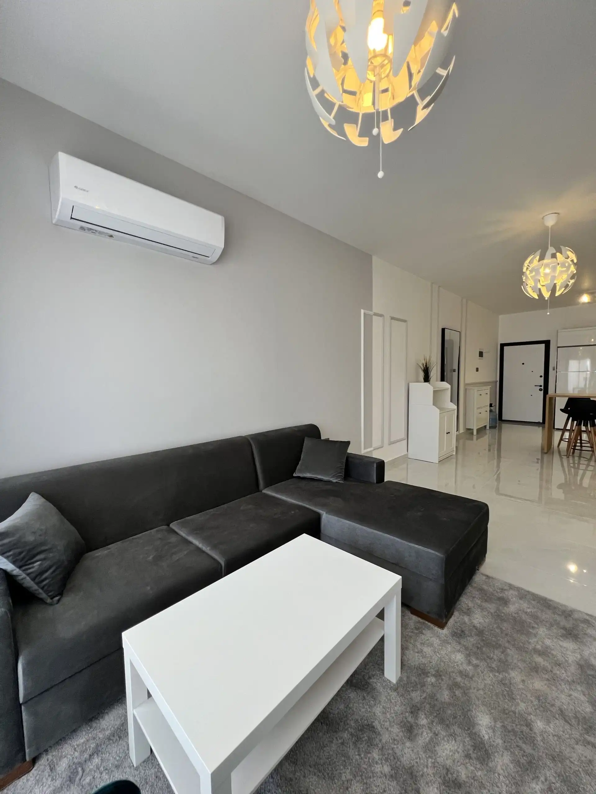 Apartment interior with black sofa and white coffee table.