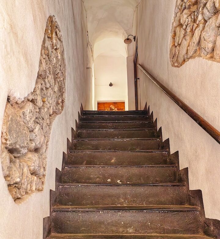 Interior view of a rustic stone staircase in a historic building in Bordighera Alta, Liguria.