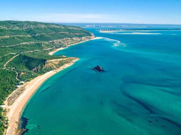Beautiful coastal view of Setubal with sandy beaches and lush green hills.